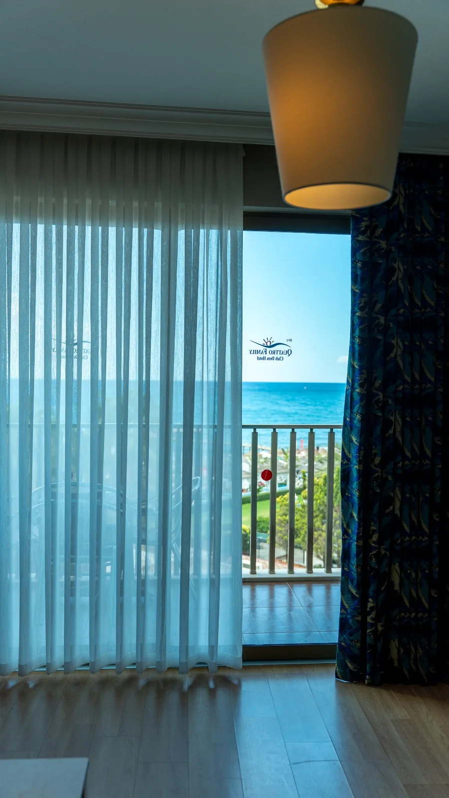 Otel odasında balkon kapısı boyunca tül ve desenli fon perde uygulaması